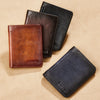 Three genuine leather bifold wallets in brown, black, and navy shades displayed on a beige surface.