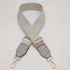 A beige braided nylon bag strap with metal hooks shown against a light background.