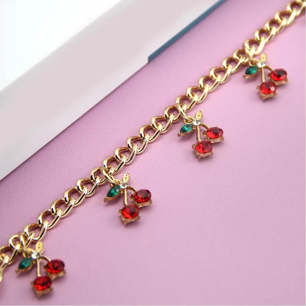 Gold chain necklace with red and green gemstone pendants