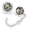 Silver bag hook with a circular frame featuring a cat face surrounded by flowers