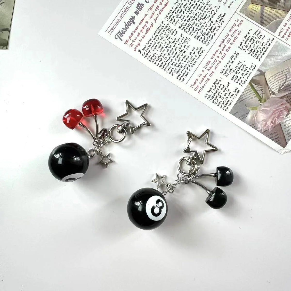 A black and white Y2K 8 ball keychain charm with a star and a three-ball design.