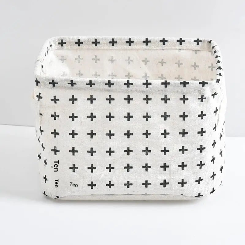 A white storage basket with a grid pattern of black plus signs, designed for desk organization.