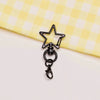A black star-shaped metal keychain clasp set resting on a yellow checkered fabric.