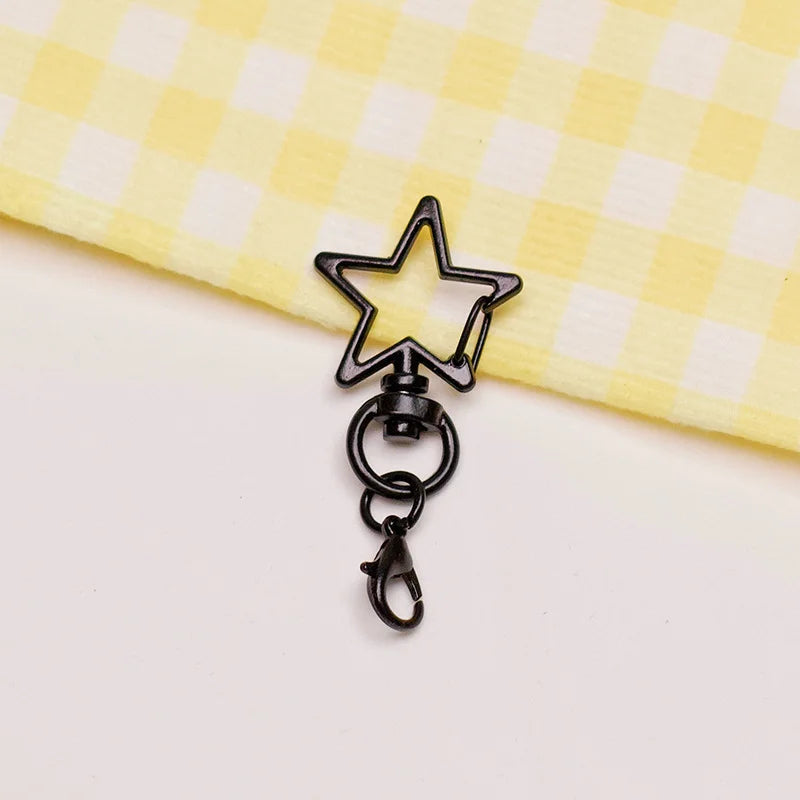 A black star-shaped metal keychain clasp set resting on a yellow checkered fabric.