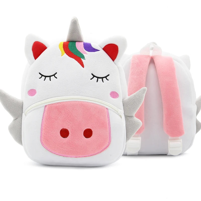 A white and pink unicorn-themed plush backpack with a rainbow horn and ears.