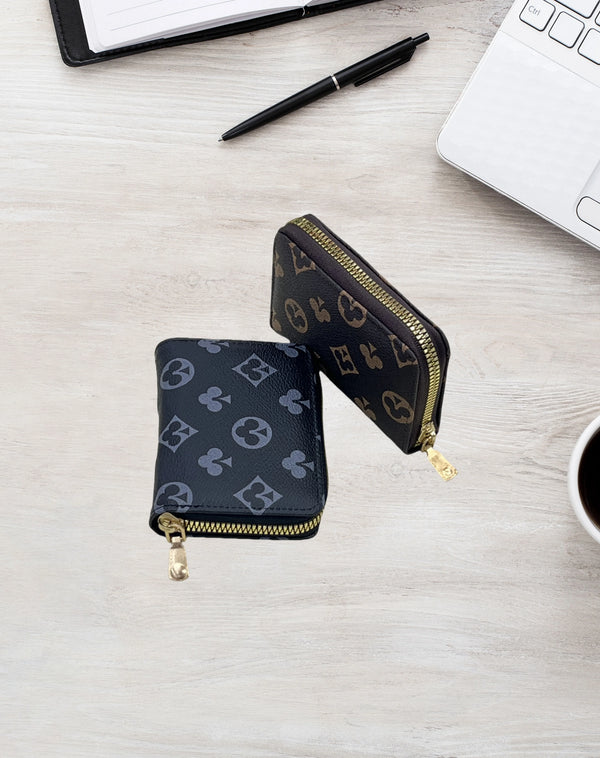 Schwarzes Zip-Wallet mit goldenen Akzenten auf hellem Holz neben Laptop und Stift