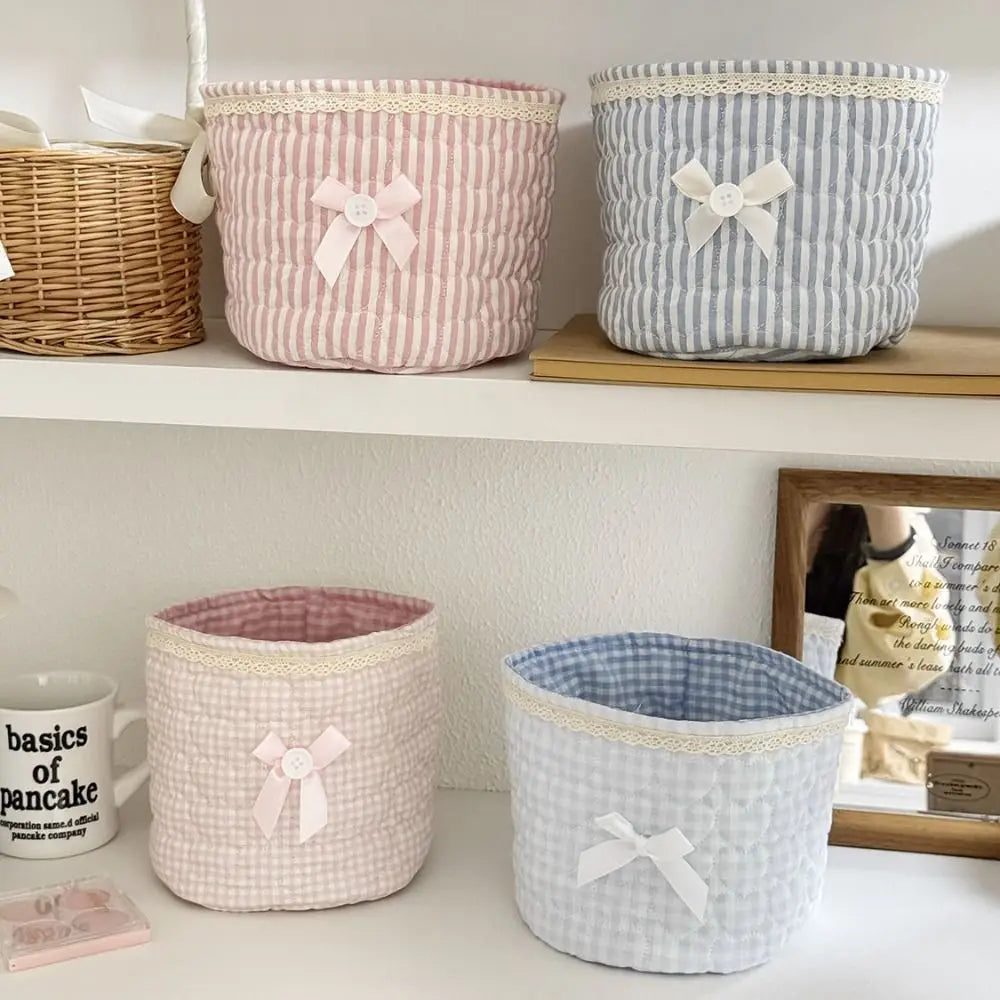 Colección de cestas de almacenamiento de corazón de algodón acolchado en rayas rosa y azul, exhibidas en un estante.