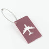 A maroon aluminum luggage tag with a silver cord attached, featuring a white airplane silhouette.