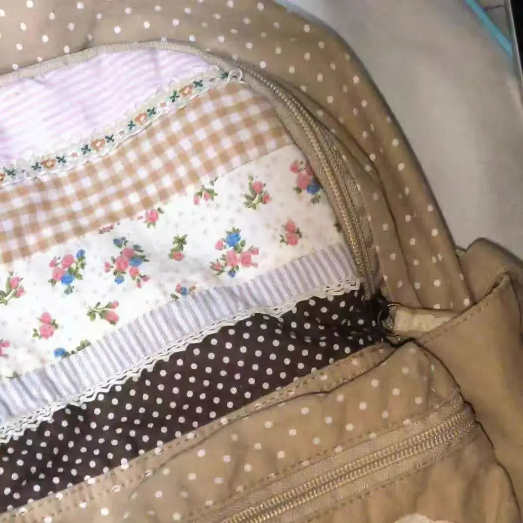 Close-up of a vintage floral print backpack featuring pastel and earth tones with various fabric layers.