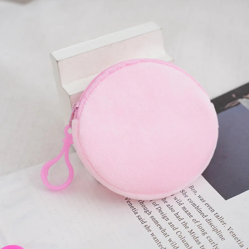 A pink capacity backpack with a zipper and pink strap resting on a white surface.