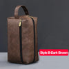 A dark brown waterproof PU leather travel toiletry bag with a zipper on a gray background.