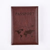 A dark brown leather passport holder embossed with a world map silhouette.