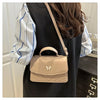 A beige textured shoulder messenger bag with a strap is shown against a dark background.