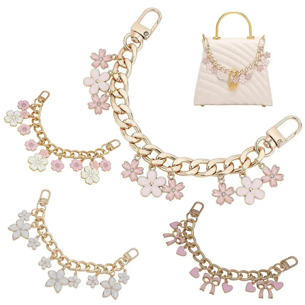 Accesorio de cadena de oro con corazones de esmalte y flores de cerezo, mostrado junto a un bolso acolchado.