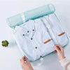 A light blue fabric storage organizer set featuring a shirt and a matching fabric pouch.