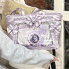 A light purple transparent shoulder tote bag decorated with sheer fabric, bows, and a central charm.