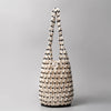 A beige beaded clutch bag with a diamond lattice pattern and a looped handle.