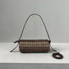 A vintage cow leather cylinder shoulder bag with a brown and black houndstooth pattern displayed on a white surface.
