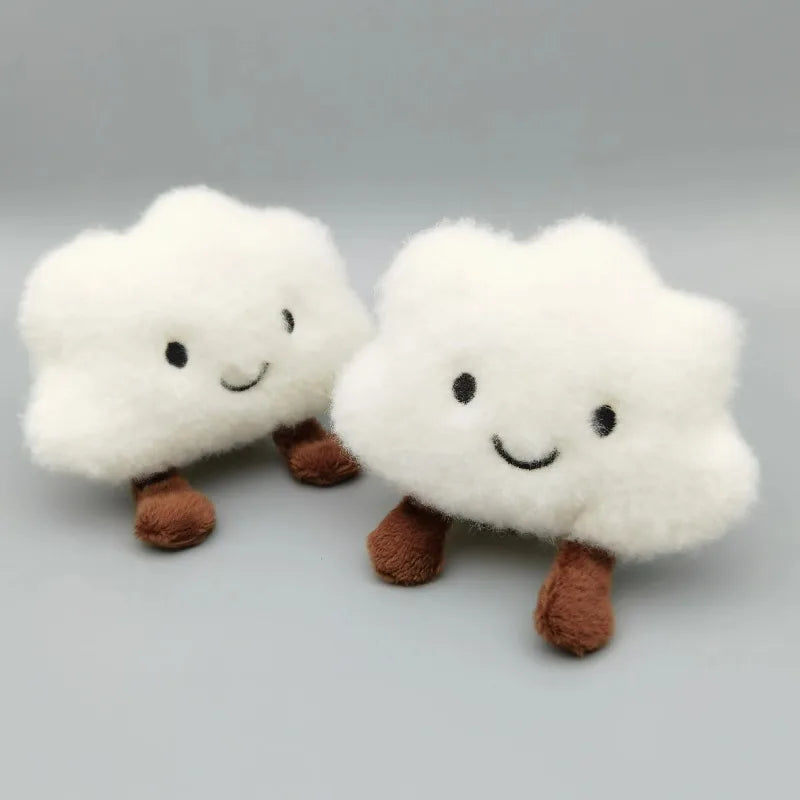 A pair of white fluffy cloud-shaped plush keychains with brown feet.