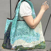 A light blue and green patterned foldable nylon shopping tote bag carried by a person.
