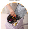 A person is opening a light purple insulated picnic cooler backpack, revealing various items inside.