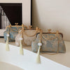 A collection of embroidered silk evening clutches in blue and beige tones with gold chain straps displayed on a white surface