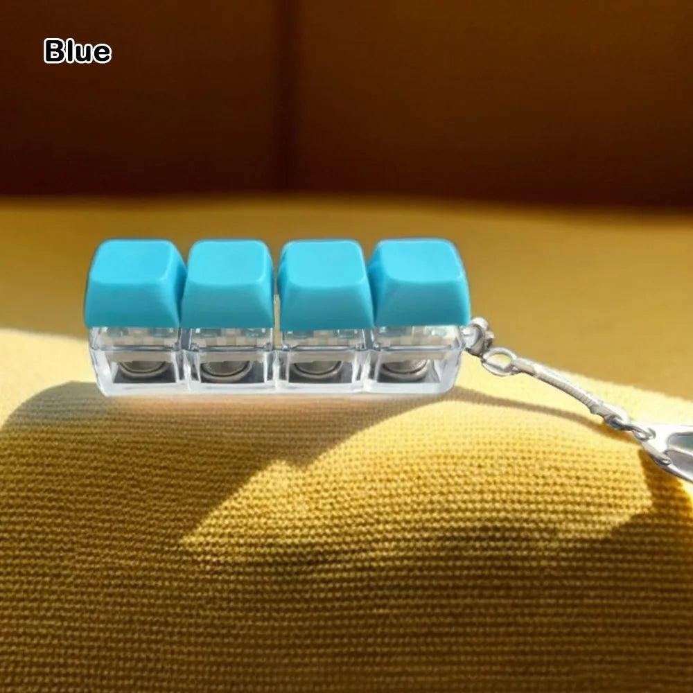 A row of light blue tactile stress relief keyboard fidget toys attached to a silver chain, resting on a yellow fabric.
