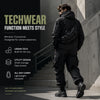 A man wearing a black techwear jacket and pants with a tactical sling waist pack stands on an outdoor staircase.