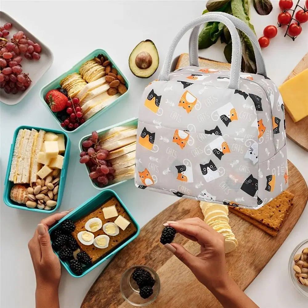 Sac à déjeuner Oxford réutilisable rempli de fruits et fromages frais sur une planche en bois.