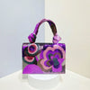 A purple and pink sequin embroidered floral clutch bag with a purple strap displayed on a white pedestal.