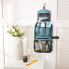 Sac de toilette voyage imperméable bleu sarcelle avec produits de soin et loofah jaune sur une étagère blanche.