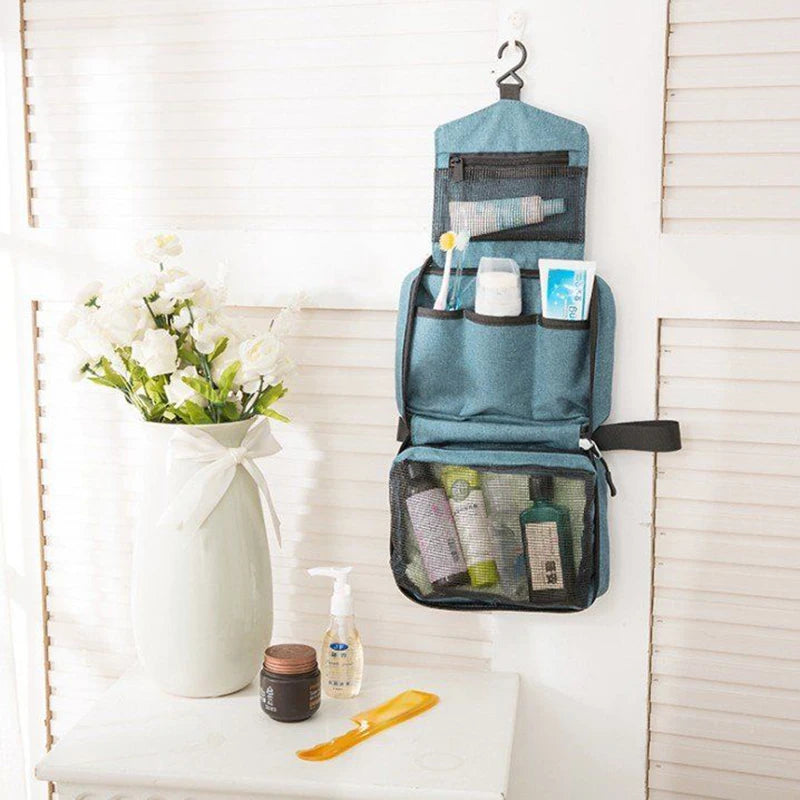 Sac de toilette voyage imperméable bleu sarcelle avec produits de soin et loofah jaune sur une étagère blanche.