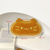 A round, golden-orange cat-shaped plush pencil pouch with embroidered features.