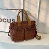 A brown corduroy tote bag with adjustable straps resting on a white surface.