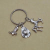 Silver keychain set featuring a cowboy boot, hat, and horseshoe charms.