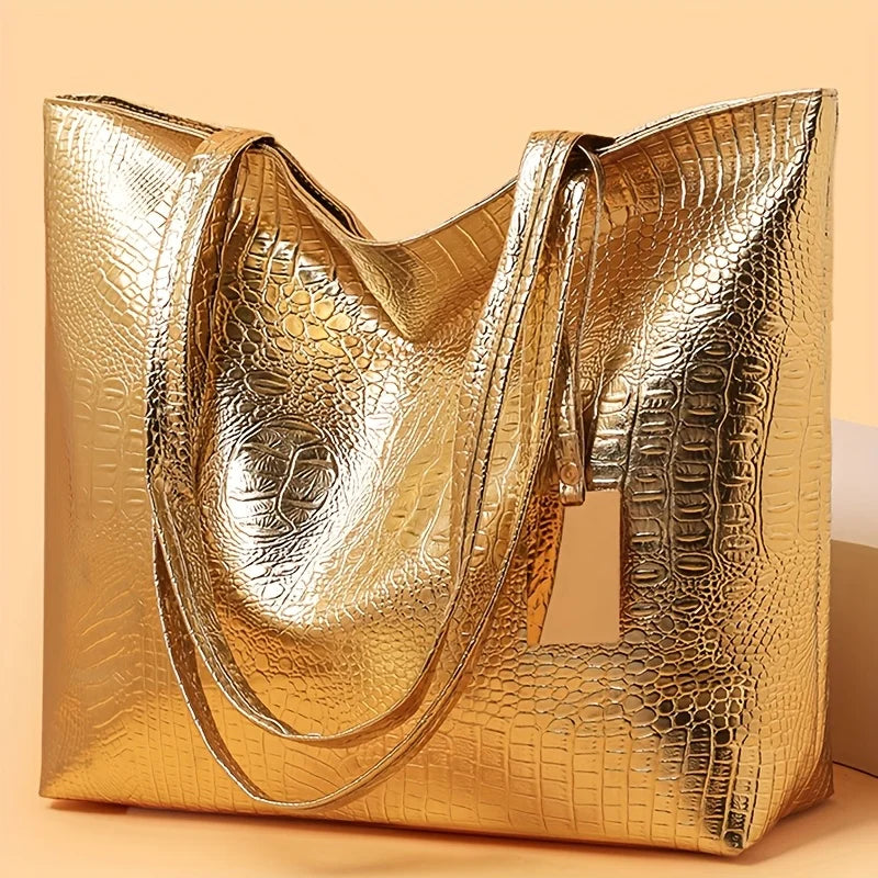 A golden metallic crocodile print zipper tote bag displayed on a light background.
