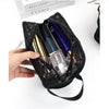 A hand holds a black mesh transparent makeup storage bag filled with various cosmetic bottles.