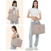 A woman holds a beige quilted padded tote bag with multiple pockets.