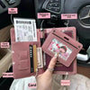 A pink passport wallet holding various cards and a signature pen next to a car interior.