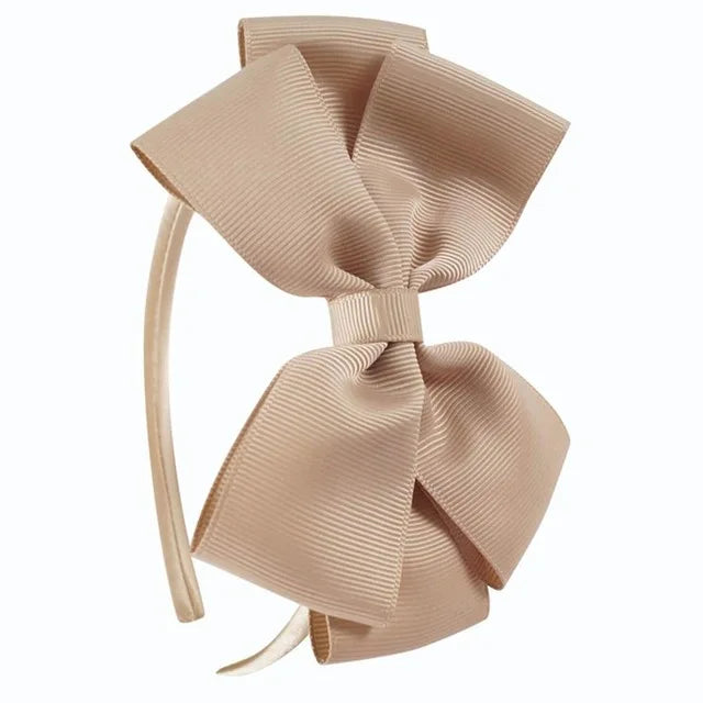 A light beige ribbed fabric bow headband shown against a white background.
