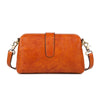 A brown genuine leather crossbody bag with a top buckle closure.
