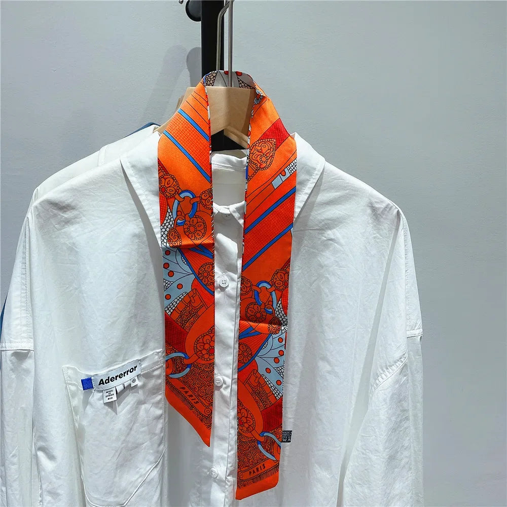 White shirt with an orange and blue patterned silky twill ribbon scarf displayed on a hanger.