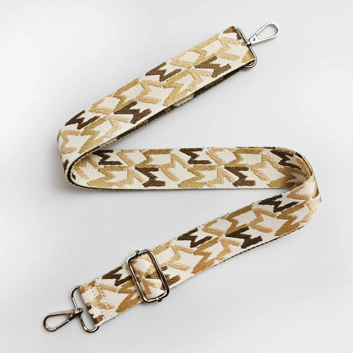 A beige and brown jacquard patterned strap for an adjustable wide crossbody bag.