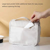 A hand is accessing a large back pocket on a white waterproof makeup organizer bag to retrieve an item.