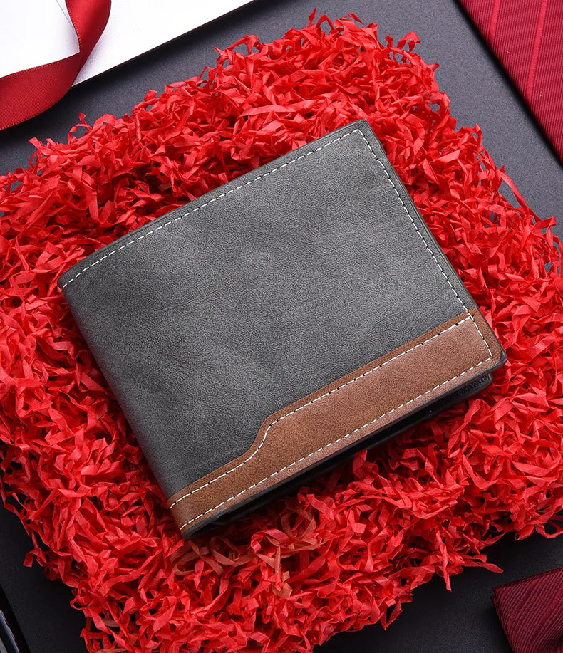 A dark gray PU leather men's wallet with a brown accent, resting on a vibrant red, fluffy material.