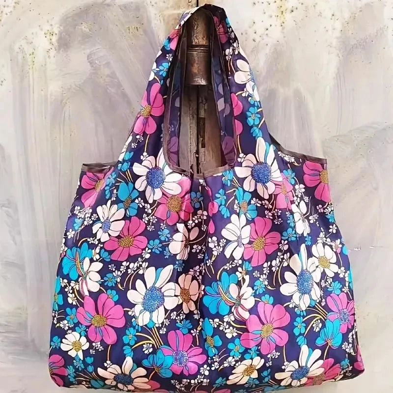A floral patterned shopping tote bag featuring pink, white, and blue flowers.