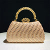 A light pink crystal-embellished evening clutch bag with a gold chain strap and crown embellishment.