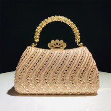 A light pink crystal-embellished evening clutch bag with a gold chain strap and crown embellishment.