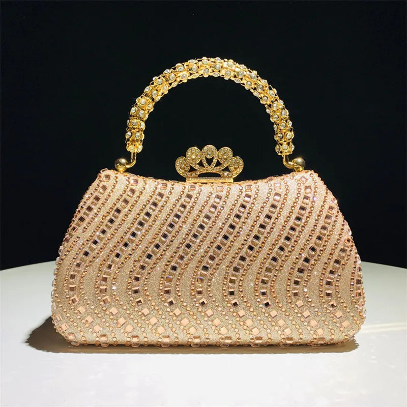 A light pink crystal-embellished evening clutch bag with a gold chain strap and crown embellishment.