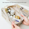 A beige makeup organizer pouch with an elastic band holding various bottles and cosmetics.